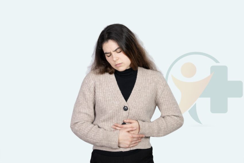 Vrouw houdt haar buik vast met een pijnlijke uitdrukking en toont symptomen van constipatie