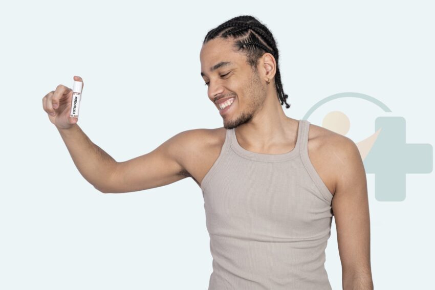 Persoon in een tanktop die glimlacht terwijl hij een klein flesje met het label oestrogeen vasthoudt als onderdeel van feminiserende hormoontherapie