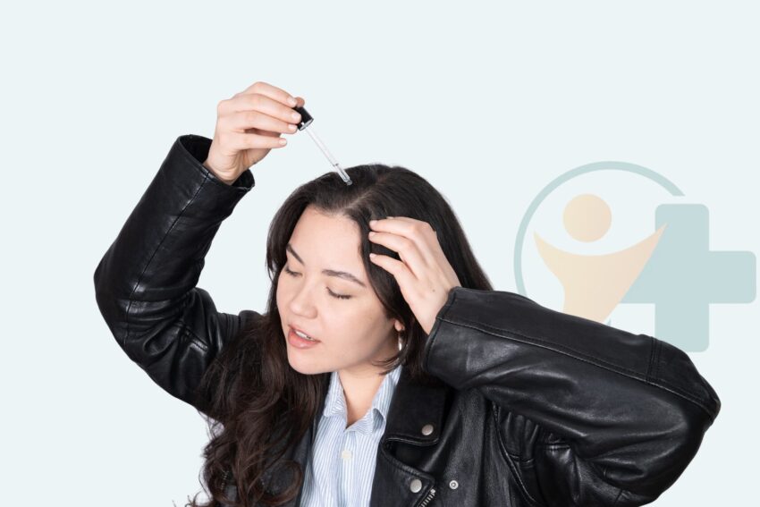 Woman using a dropper to apply hair growth serum to her scalp as a visual reference for hair growth solutions