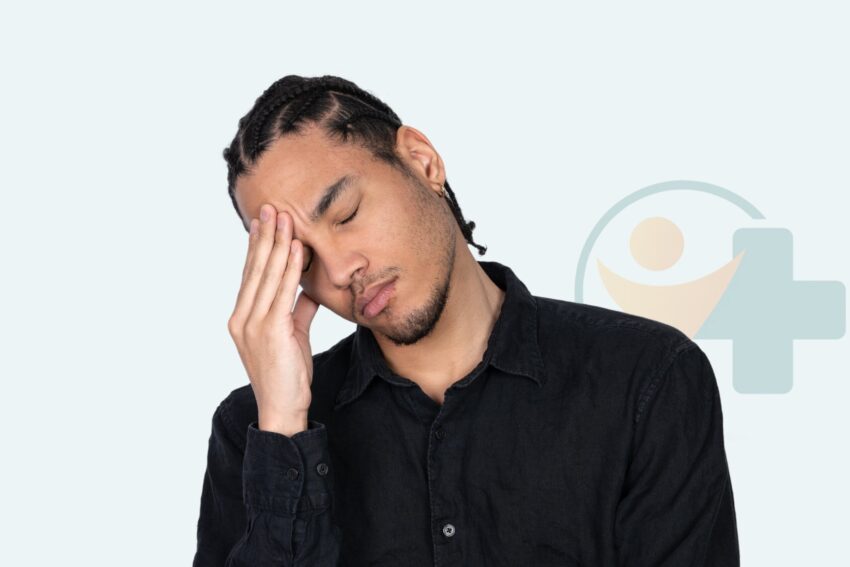 Man touching his forehead with a pained expression, representing discomfort from herpes outbreaks treated at Transtoyou